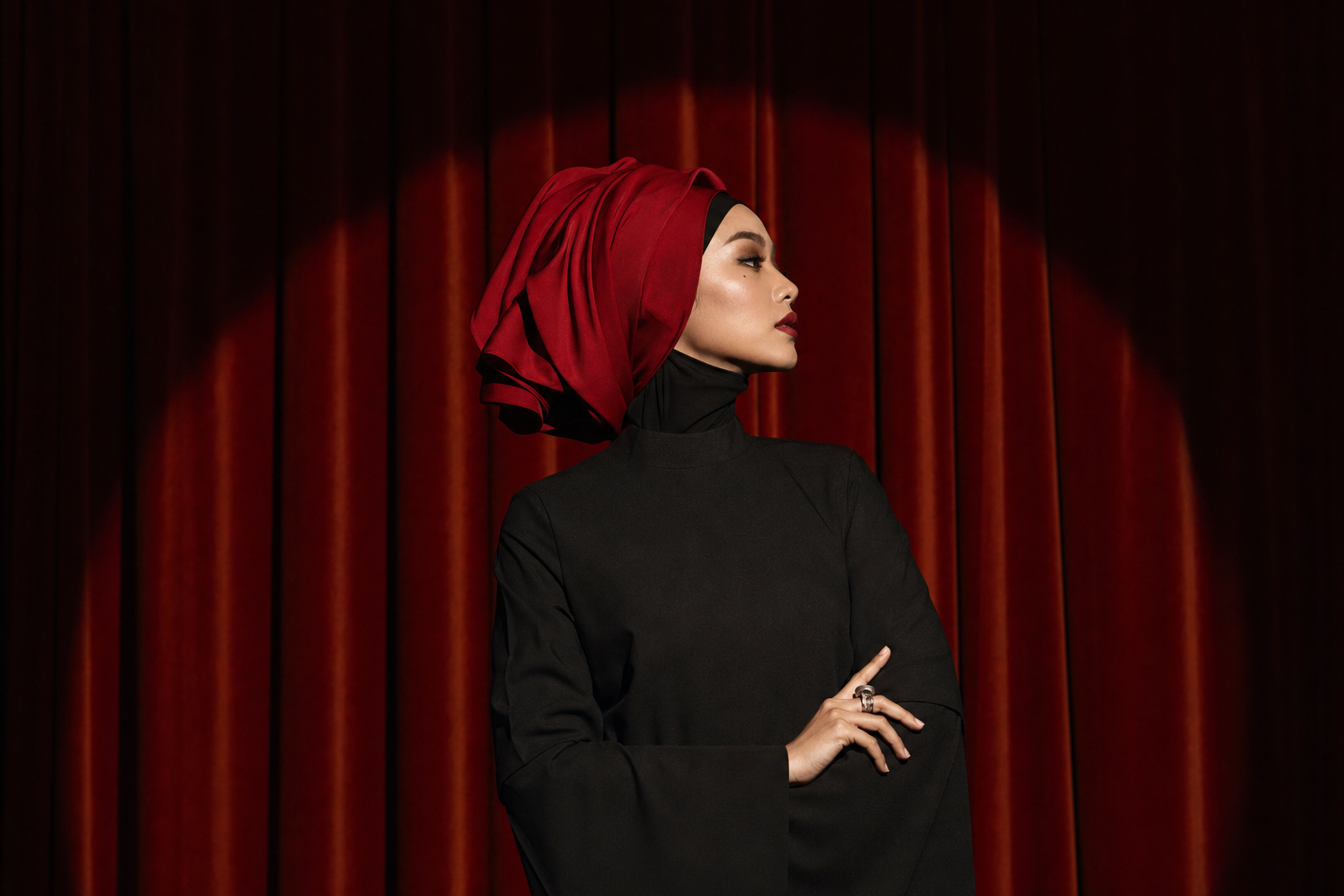 Kırmızı tiyatro perdesi önünde siyah abayalı kadın model